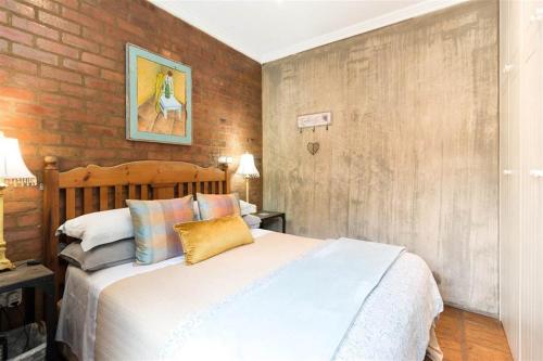 比勒陀利亚Ambiance Guesthouse的一间卧室设有一张床和砖墙
