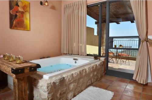 萨法德קאמי מלון בוטיק עם ממ"ד - Kami Boutique Hotel的带阳台的客房内的按摩浴缸