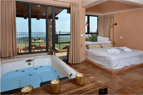 萨法德קאמי מלון בוטיק עם ממ"ד - Kami Boutique Hotel的一间带浴缸和床的卧室以及一个阳台