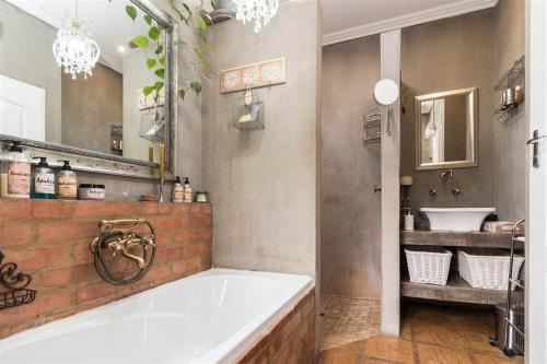 比勒陀利亚Ambiance Guesthouse的一间带大浴缸和水槽的浴室