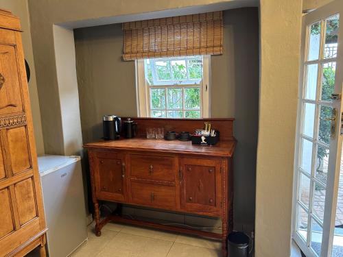 比勒陀利亚Battiss Guest House的一间带木制梳妆台和窗户的浴室