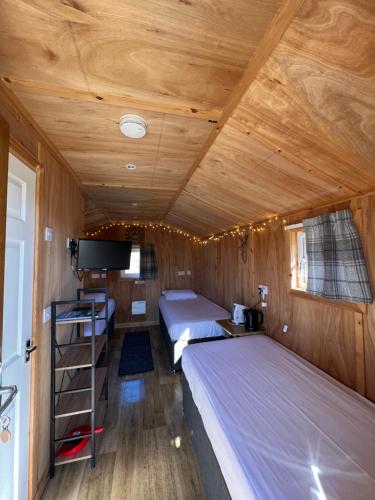 波特里Isle Of Skye Camping Pods的一间设有两张床和一台电视的房间