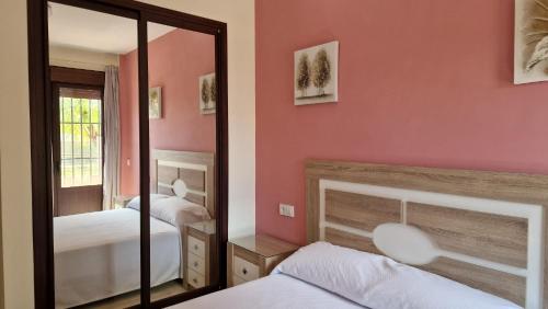 埃斯帕尔蒂纳斯HOTEL NUEVO ESPARTINAS的一间卧室配有两张床和镜子