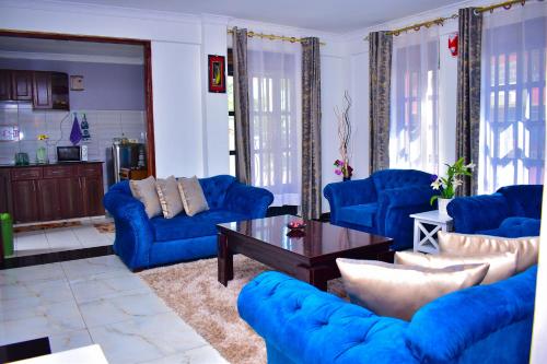 基苏木Rozy Penthouse的客厅配有蓝色的沙发和咖啡桌