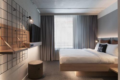 洛桑Moxy Lausanne City的酒店客房设有床和窗户。