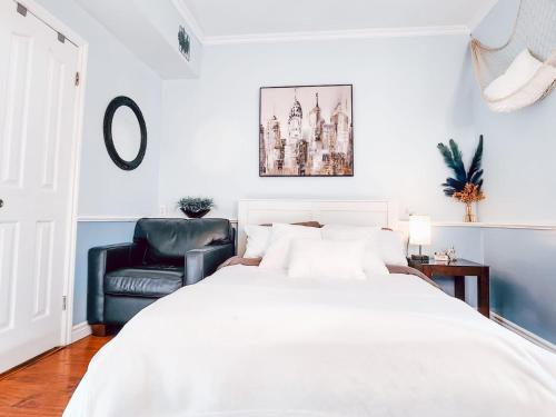 埃德蒙顿Hotel-Like stay!的卧室配有白色的床和黑色真皮座椅。