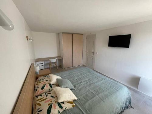 塞扬Appartement neuf avec jacuzzi privatif et piscine的一间卧室配有一张大床和一台平面电视