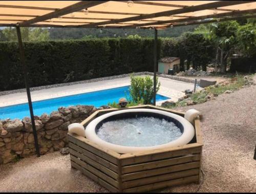 塞扬Appartement neuf avec jacuzzi privatif et piscine的一个带游泳池的庭院里设有一个大浴缸