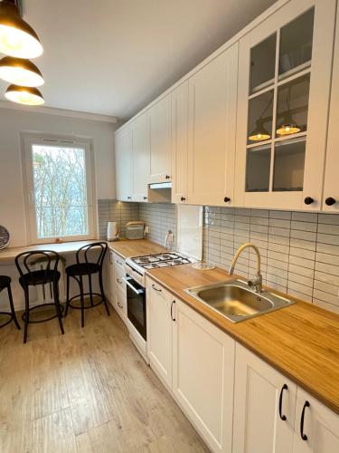 格丁尼亚Zatoka spokoju的厨房配有白色橱柜和水槽