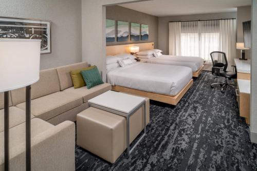 亨廷顿Delta Hotels Huntington Downtown的酒店客房,设有两张床和一张沙发