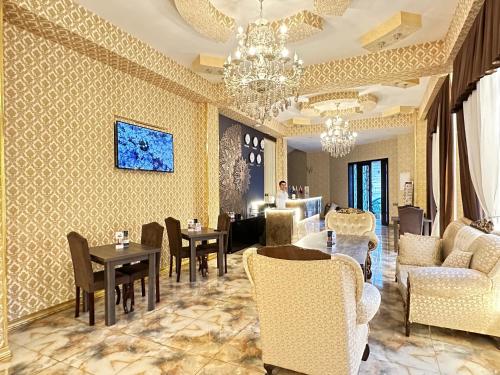 巴库Istanbul Gold Hotel的客厅配有桌椅和吊灯。