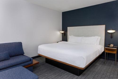 塔拉哈西北塔拉哈西庭院酒店/I-10首府环路的一间卧室配有一张床和一张蓝色椅子