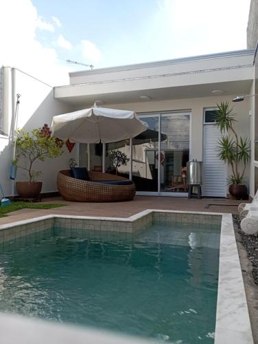亚美利加纳toledo casa completa的一座带遮阳伞的房屋前的游泳池