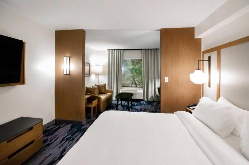 路易斯威尔Fairfield by Marriott Inn & Suites Louisville Airport的酒店客房设有一张大床和一张沙发。