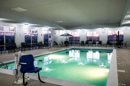 路易斯威尔Fairfield by Marriott Inn & Suites Louisville Airport的一个带蓝色椅子和桌椅的游泳池
