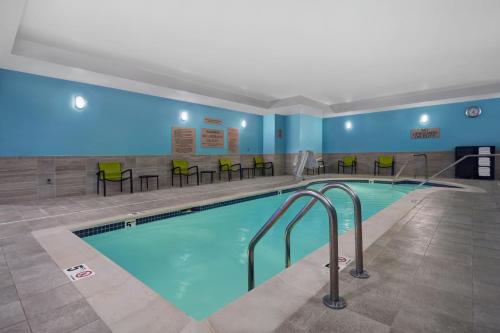 克伦威尔SpringHill Suites by Marriott Hartford Cromwell的游泳池位于酒店客房内,配有桌椅