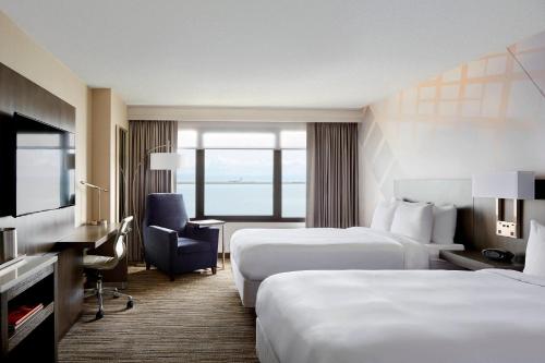 伯林格姆旧金山机场万豪水岸酒店的酒店客房,配有两张床和椅子