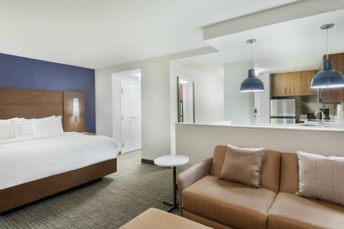 布法罗Residence Inn by Marriott Buffalo Downtown的酒店客房,配有床和沙发