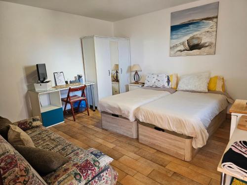 Playa del HombreEstudio Brisa Canaria的一间卧室配有两张床、一张桌子和一张沙发