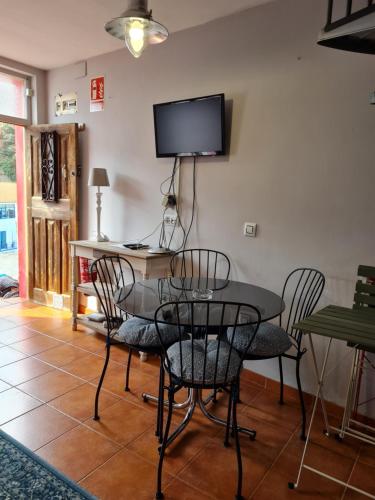 库迪列罗Casina del Puerto的一间带桌椅和电视的用餐室
