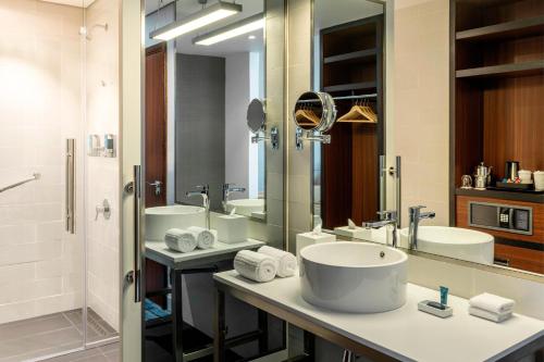 迪拜Aloft Dubai South的一间带两个盥洗盆和大镜子的浴室