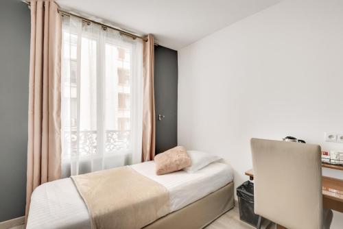 巴黎L'Oasis Montparnasse的一间小卧室,配有床和窗户