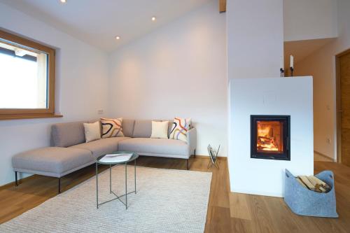 拉瓦莱Ciasa Plandros Apartments的带沙发和壁炉的客厅