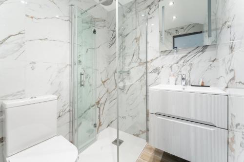 巴黎L'Oasis Montparnasse的带淋浴、卫生间和盥洗盆的浴室