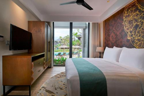 努沙杜瓦巴厘岛努沙杜瓦花园万豪酒店的一间卧室配有一张床、一台电视和一个阳台