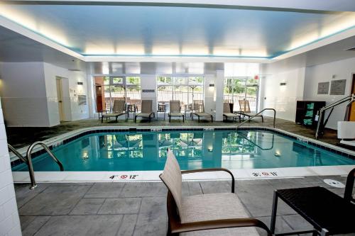 里士满里士满中洛锡安万豪费尔菲尔德套房酒店的一座酒店游泳池周围设有椅子