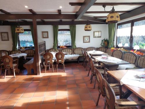AhrbrückLandgasthaus Tannenhof的用餐室设有桌椅和窗户。