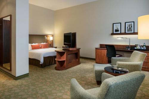 不莱梅布莱梅万豪度假酒店的酒店客房带一张床、一台电视和椅子