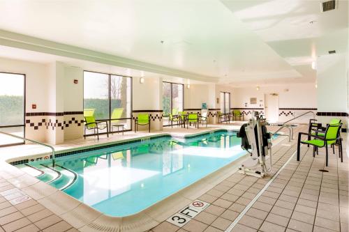 佛罗伦萨佛罗伦萨春季山丘套房酒店的一座带绿色桌椅的酒店游泳池