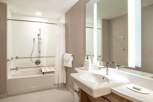 里维尔SpringHill Suites by Marriott Boston Logan Airport Revere Beach的白色的浴室设有水槽、浴缸和水槽。
