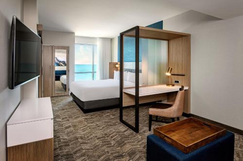 里维尔SpringHill Suites by Marriott Boston Logan Airport Revere Beach的配有一张床和一张书桌的酒店客房