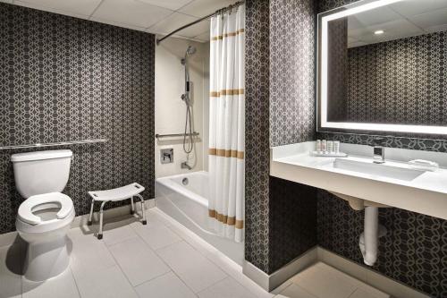 洛杉矶洛杉矶机场万豪酒店的浴室配有卫生间、盥洗盆和浴缸。