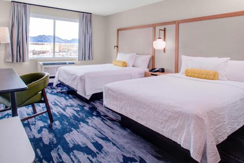 布鲁姆菲尔德Fairfield Inn & Suites by Marriott Boulder Broomfield/Interlocken的酒店客房设有两张床和窗户。
