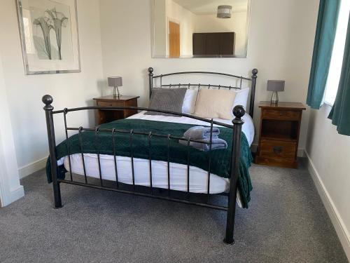 红山Watercolour House的一间卧室配有一张带绿色棉被的床