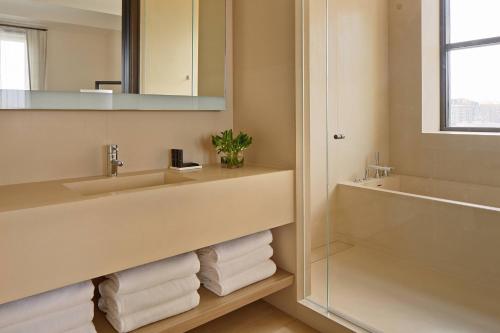 纽约The New York EDITION的浴室配有盥洗盆、镜子和毛巾