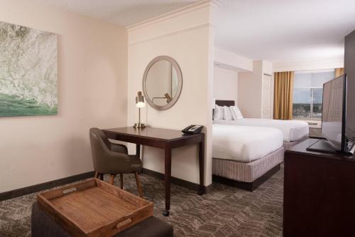 奥兰多奥兰多机场春季山丘套房酒店的酒店客房配有书桌、床和镜子