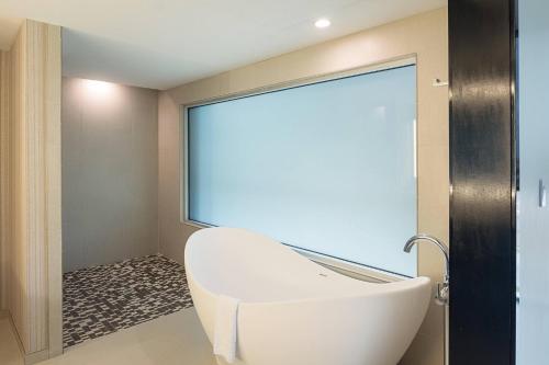 沃思堡沃思堡化石溪万豪春季山丘套房的一间带白色浴缸和大窗户的浴室