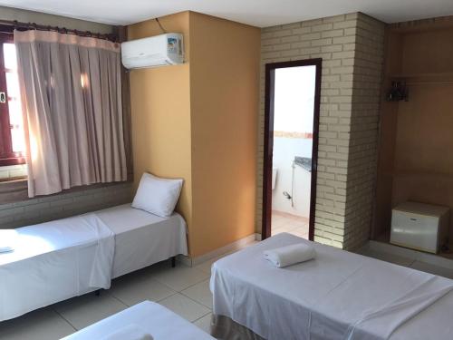戈亚尼亚Rede Andrade Goiania Centro的酒店客房设有两张床和窗户。