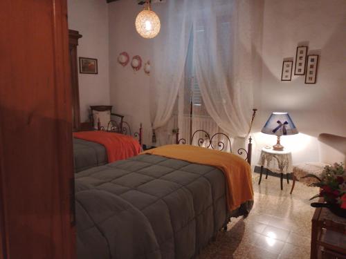 基亚恩尼Casa Tarrini的一间卧室设有两张床、一盏灯和一扇窗户。