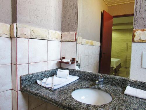 戈亚尼亚Rede Andrade Goiania Centro的一间带水槽和镜子的浴室