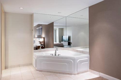 圣约翰斯三角洲圣约翰酒店和会议中心的一间带大镜子和浴缸的浴室