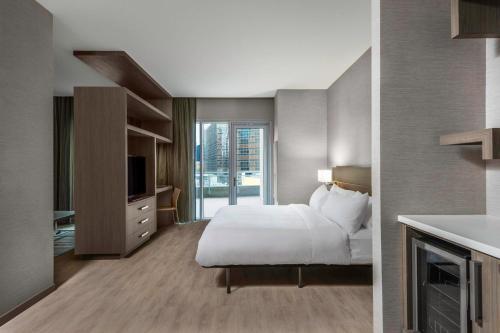 夏洛特AC Hotel by Marriott Charlotte City Center的酒店客房,配有床和电视
