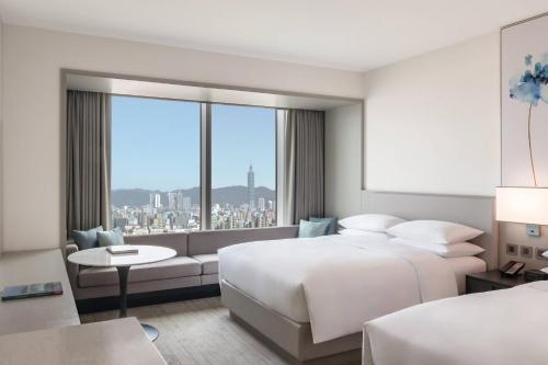 台北台北国泰万怡酒店的酒店客房设有两张床和大窗户。