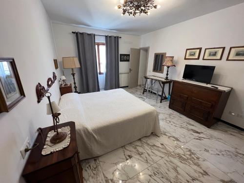 萨杜勒尼亚Le Camere dei Magi的一间卧室配有一张床和一台平面电视
