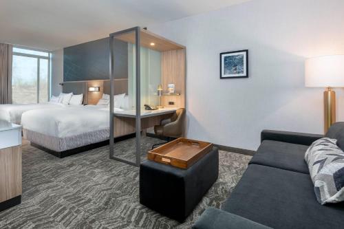 WestfieldSpringHill Suites by Marriott Indianapolis Westfield的酒店客房,配有床和沙发