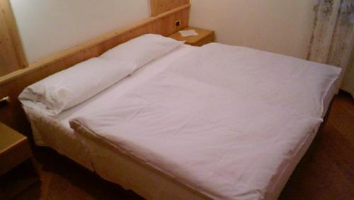 摩德纳迪-坎皮格里奥Campiglio Bilocale Dolomiti的一张床上的白色床单